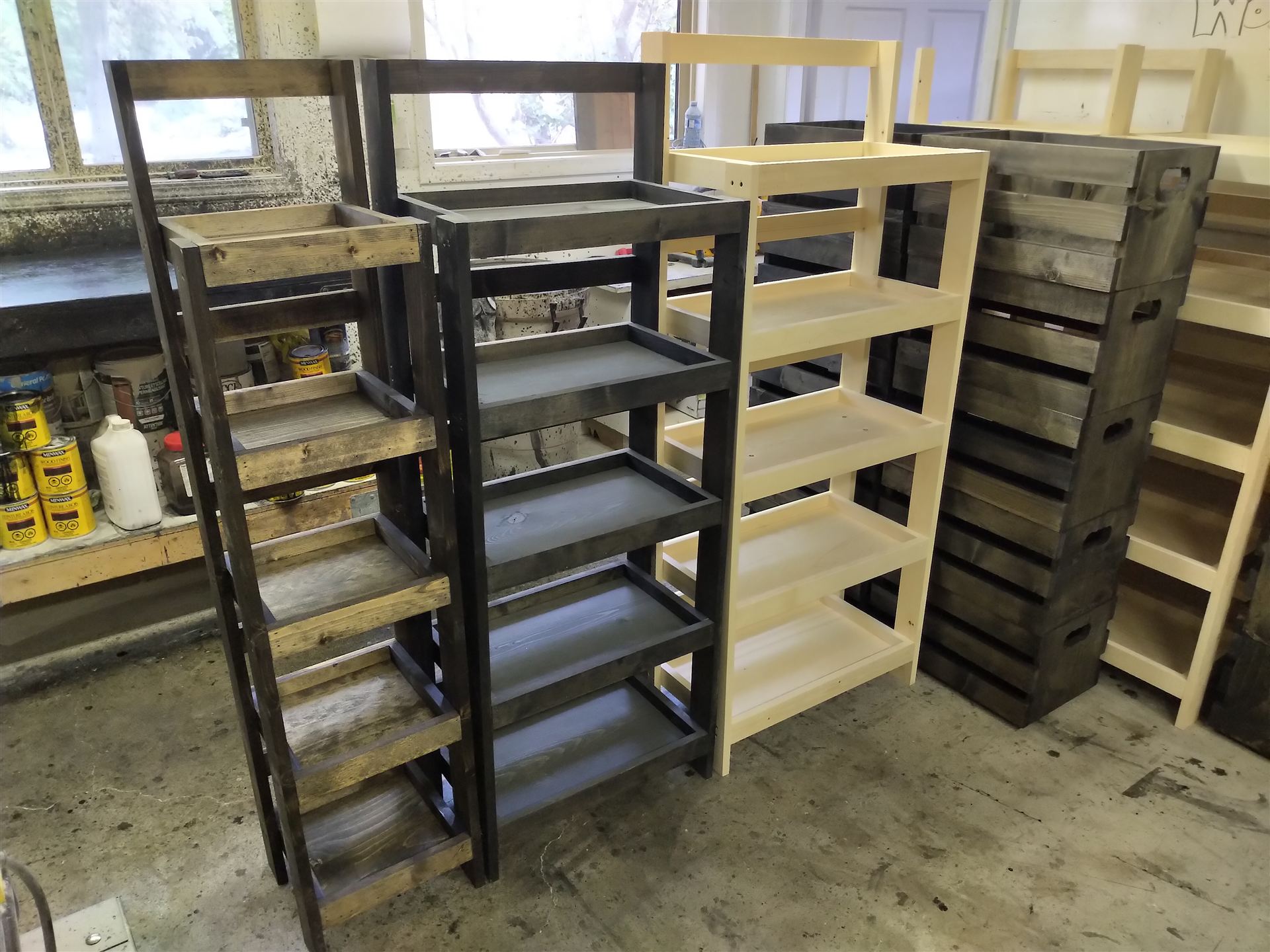 Row of tall pine shelving units built by Hazell Woodworks, in a range of stains